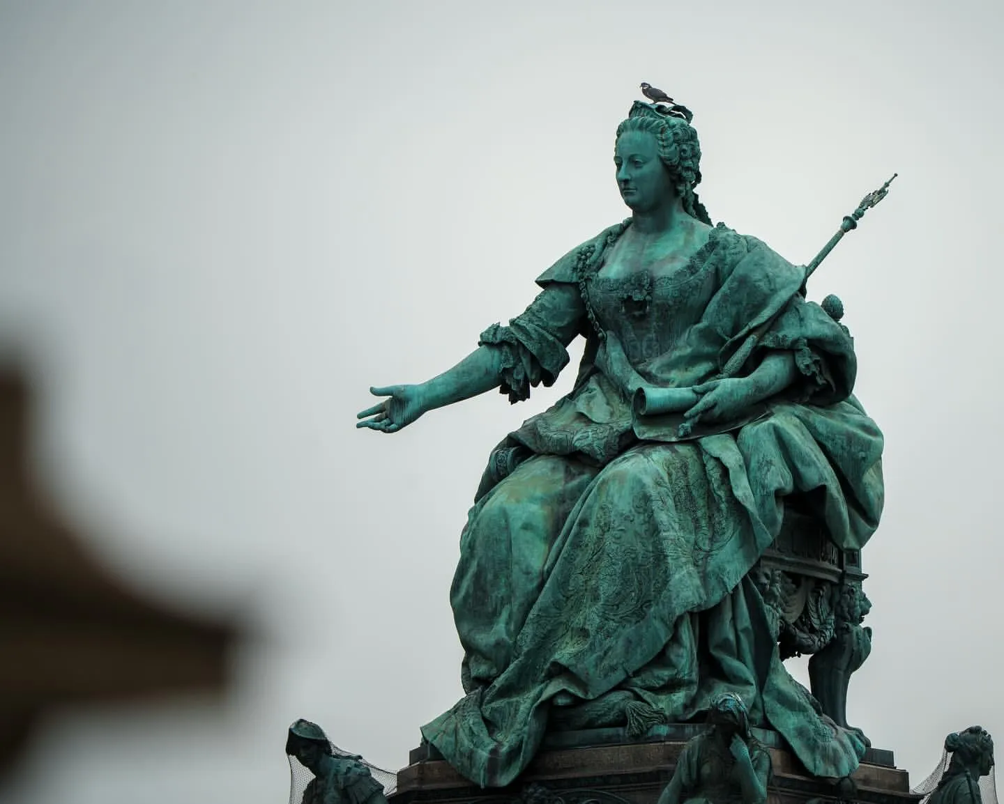 The bronze Maria Theresa monument, the empress enthroned with a sceptre and one hand outstretched, a pigeon on her crown