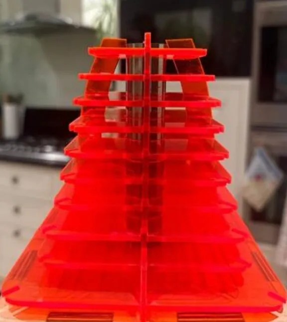 A close-up of the lamp's shade: stacked fins of fluorescent red acrylic slotted onto a central spine