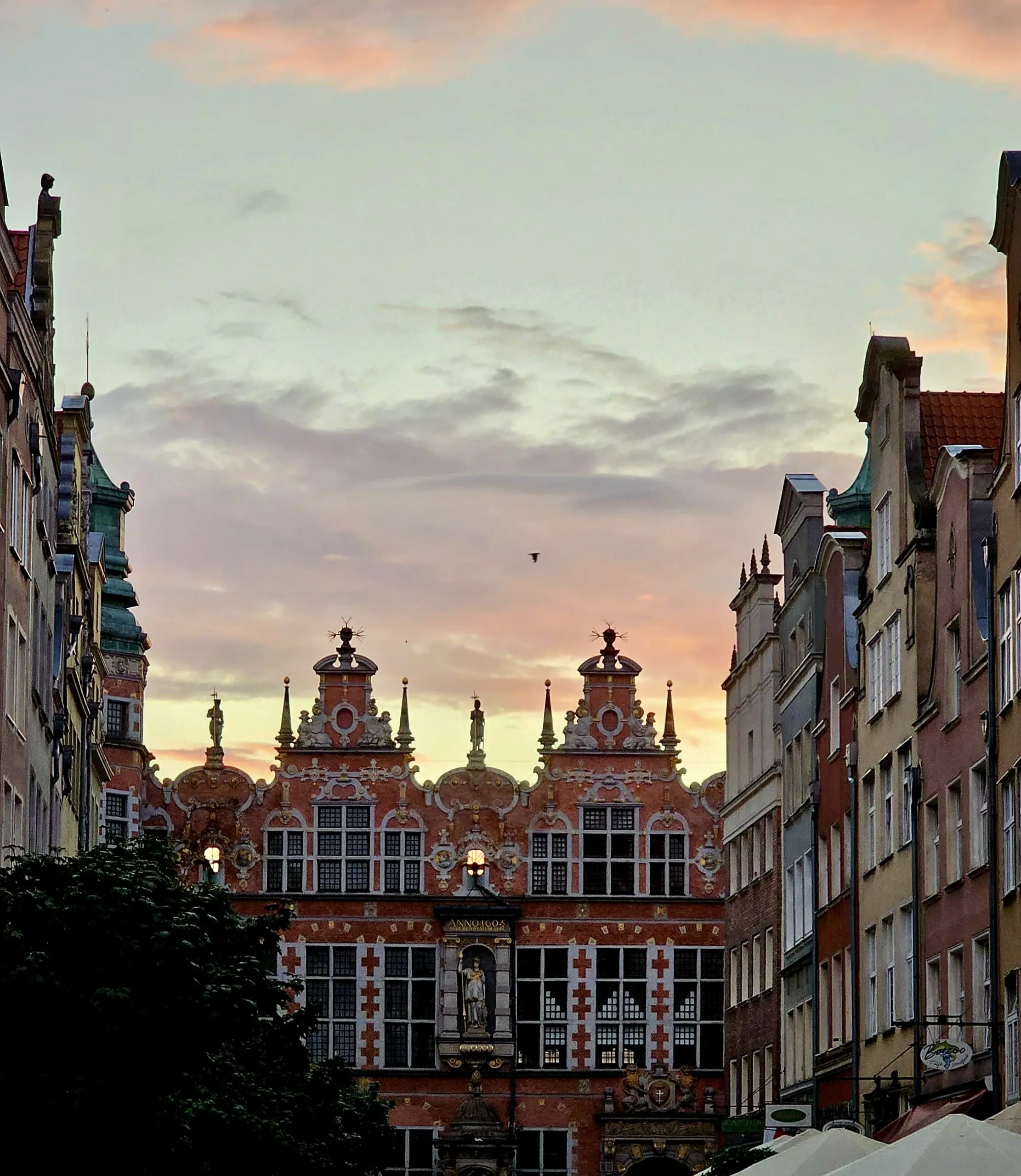 The Great Armoury at sunset, its ornate Dutch Mannerist gables and gilded detail against a pink and orange sky